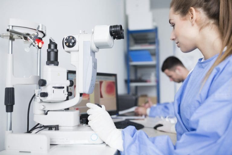 Lab technician working with microscope in lab